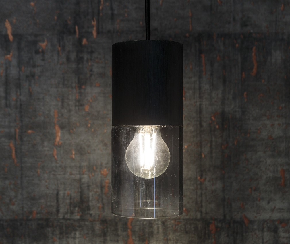 Lampe im Sole Moderne Hängeleuchte mit schwarzem und klarem Glasdesign vor einer rustikalen Tapete mit Kupferakzenten im Boutique Hotel Sole in Sterzing.