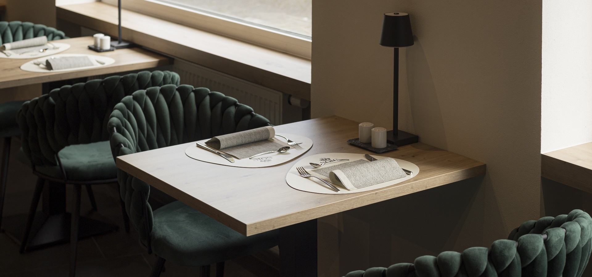 Tische im Hotel Sole Elegant gedeckter Frühstückstisch im Boutique Hotel Sole, mit stilvollen grünen Samtstühlen, minimalistischer Tischdekoration und sanftem Lichteinfall.