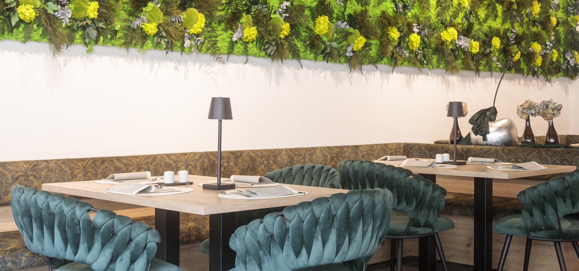 Frühstücksraum Boutique Hotel Sole Frühstücksraum des Boutique Hotel Sole in Sterzing, Südtirol. Stilvoll eingerichtet mit grünen Polsterstühlen, Holztischen und vertikaler Pflanzenwand.