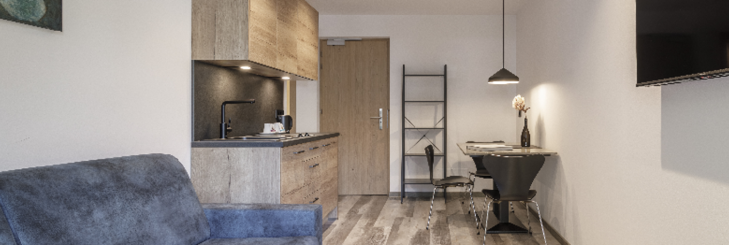 Dolomit Apartment Hotel Sole Modernes Apartment im Boutique Hotel Sole in Sterzing, Südtirol. Offene Küche, gemütliches Sofa, Esstisch aus Dolomitgestein mit Designerstühlen und Wand-TV.