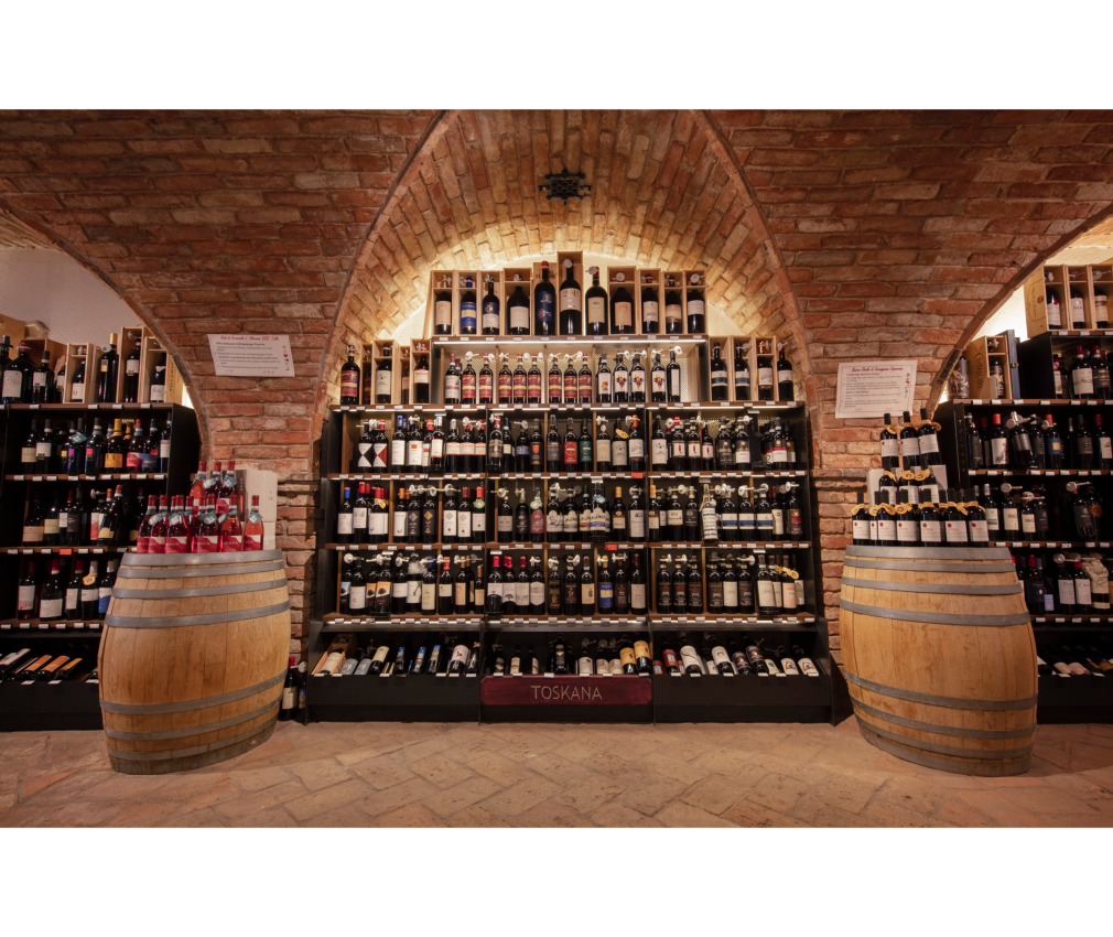 Weinregale in der Enothek Mair Mair Weinkeller bei Mair Mair in Sterzing: Ein beeindruckendes Sortiment erlesener Weine aus der Toskana, stilvoll präsentiert unter historischen Backsteinbögen.