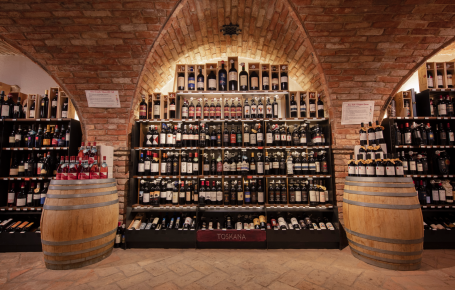 Weinkeller bei Mair Mair in Sterzing: Ein beeindruckendes Sortiment erlesener Weine aus der Toskana, stilvoll präsentiert unter historischen Backsteinbögen.