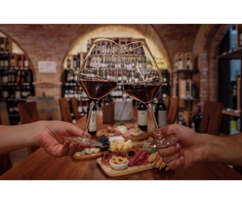 Genuss im Weinkeller Mair Mair in Sterzing Genussmoment im Weinkeller von Mair Mair in Sterzing: Zwei Gläser Rotwein beim Anstoßen, begleitet von einer edlen Käse- und Wurstplatte.