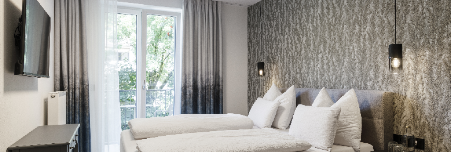 Schlafzimmer Apartment Dolomit Modernes Schlafzimmer mit gemütlichem Doppelbett, stilvollen Hängelampen und eleganter Tapete. Bodentiefe Fenster mit Balkon sorgen für viel Tageslicht.