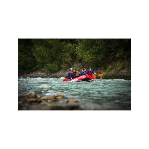Rafting in Sterzing Eine Gruppe von Menschen in Schutzwesten und Helmen beim Wildwasser-Rafting auf dem schnell fließenden Fluss Eisack, umgeben von grüner Natur bei Sterzing.