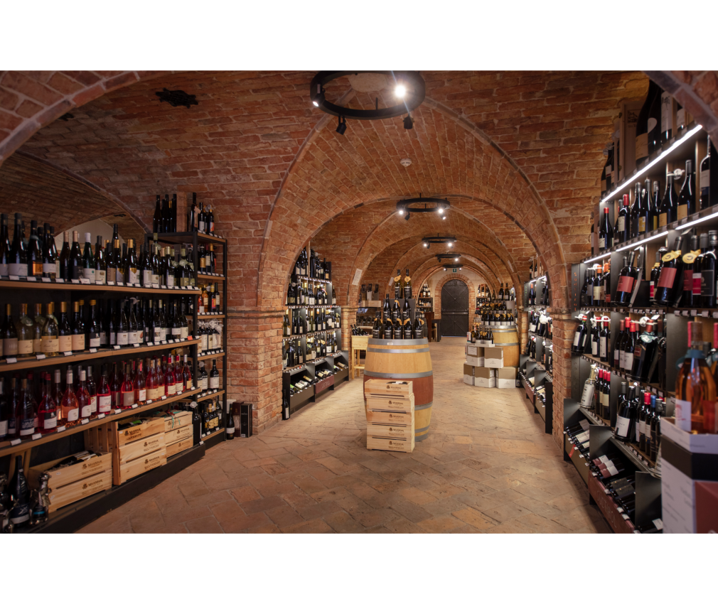Gewölbekeller Mair Mair Sterzing Historischer Weinkeller von Mair Mair in Sterzing, Südtirol: Ziegelgewölbe, edle Tropfen aus Italien und Europa, stilvoll präsentiert auf Holzfässern und Regalen.