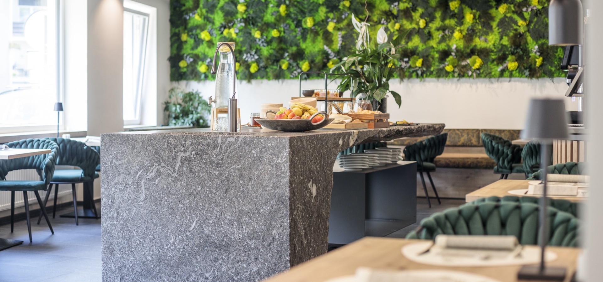 Grüner Frühstücksraum im Hotel Sole Moderner Frühstücksraum im Boutique Hotel Sole mit Naturstein-Theke, stilvollen Sitzbereichen und vertikaler Begrünung für ein elegantes Ambiente.