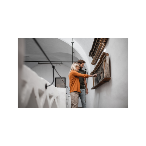 Paar erkundet eine historische Ausstellung im Rathaus von Sterzing in Südtirol. Kulturelles Erlebnis in der historischen Alpen-Stadt.