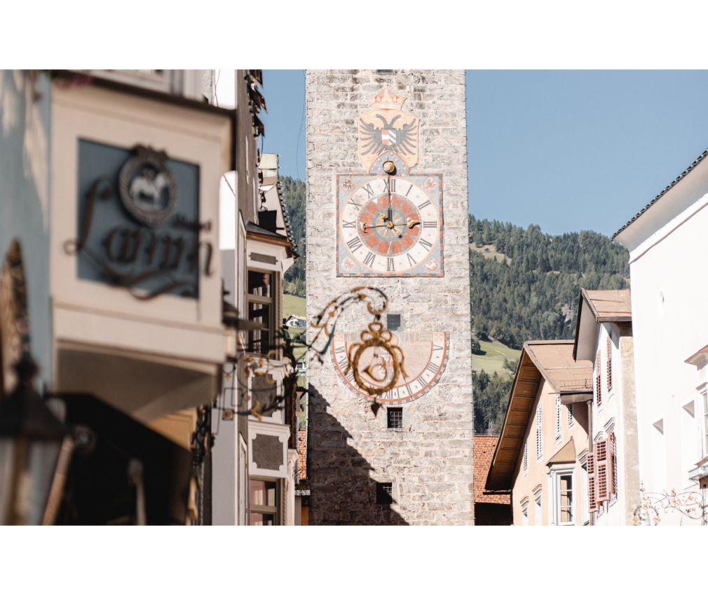 Sterzing im Sommer Historische Altstadt von Sterzing im sommer mit Erkerfenstern und dem Zwölferturm in der mitte. Im Hintergrund ist der Berg Rosskopf zu sehen.
