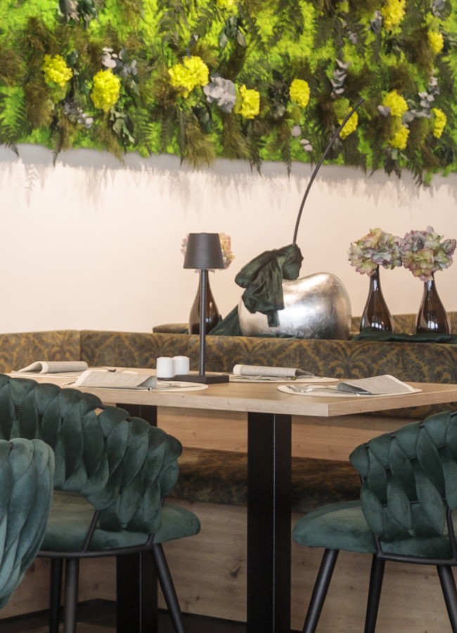 Detailaufnahme Frühstücksraum Hotel Sole Detailaufnahme des Frühstücksraums im Boutique Hotel Sole in Sterzing, Südtirol. Elegantes Interieur mit grünen Polsterstühlen, Holztischen und Deko.