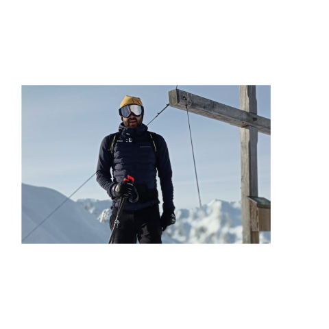 Skitour in den Alpen Gipfelerlebnis in den Alpen – Ein Skitourengeher erreicht das Gipfelkreuz mit atemberaubender Aussicht auf die verschneiten Berge Südtirols.